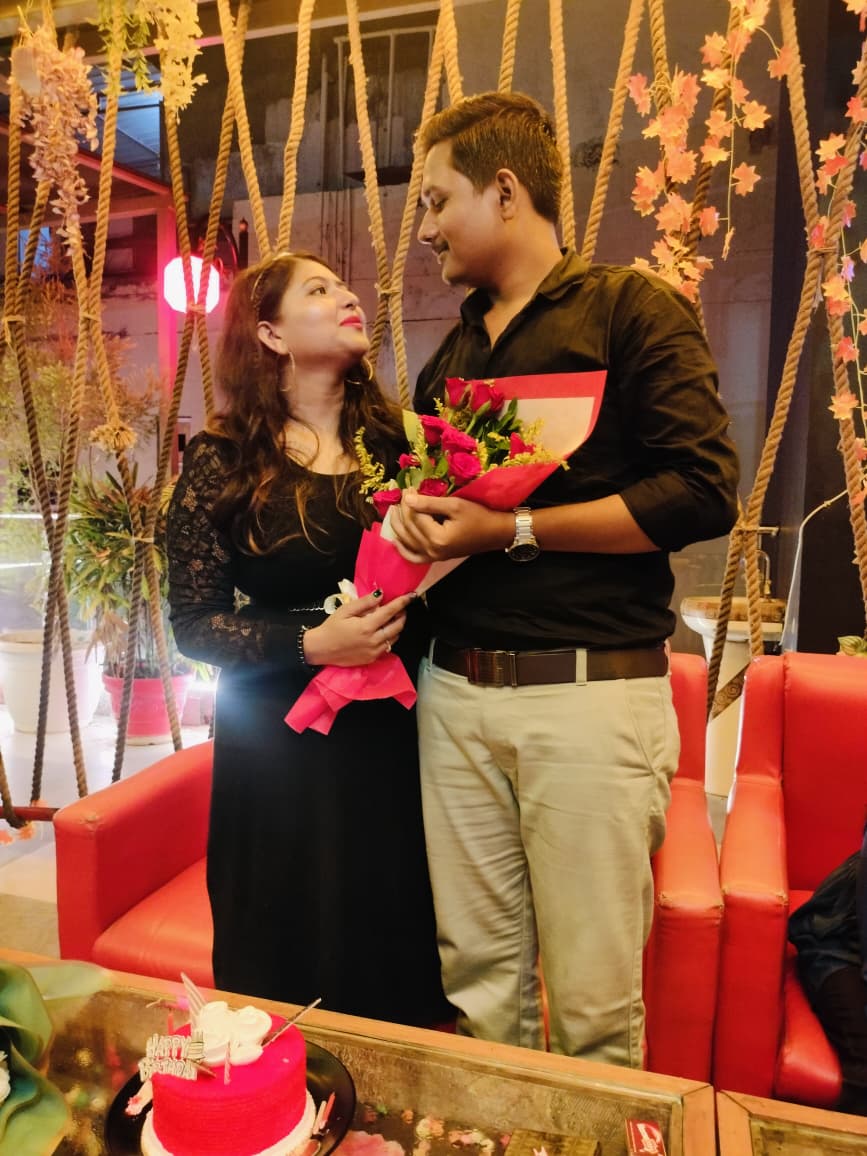 Vartika and Vaibhav holding a bouquet and looking at one another